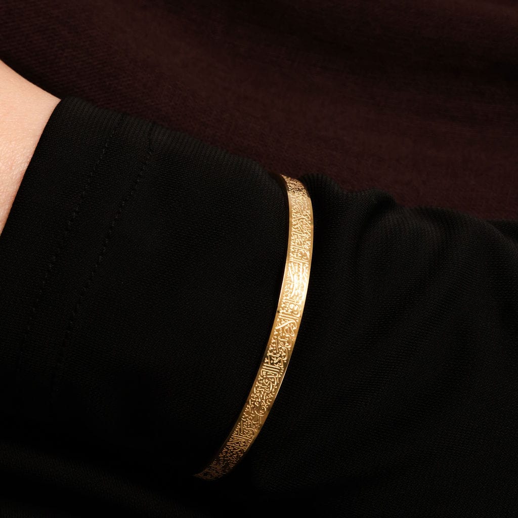 Cairo's Ayatul kursi Gold bracelet on a person's wrist against a dark background