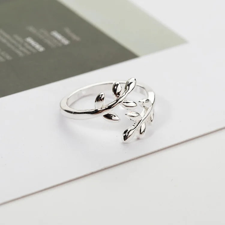 Palestine olive leaf-shaped ring on a white surface with a blurred background